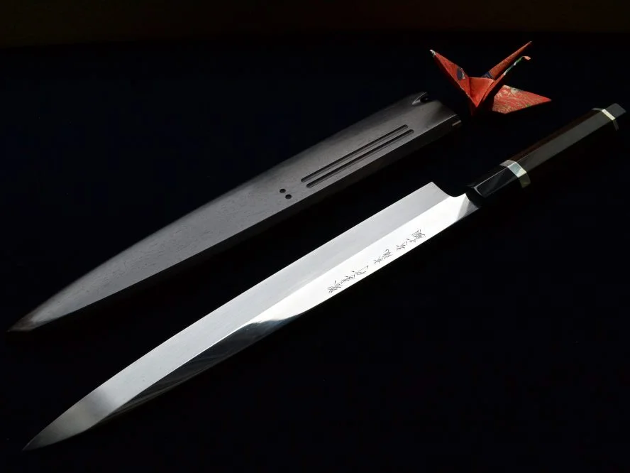 Sakai Takayuki Japanese knives with red lacquer handles fanned out on a black background